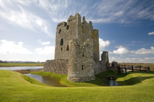 Threave Castle on a sunny day with a moat and green grass